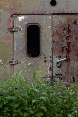  Rusty scratched metal texture of trailer carcass with craced window.
