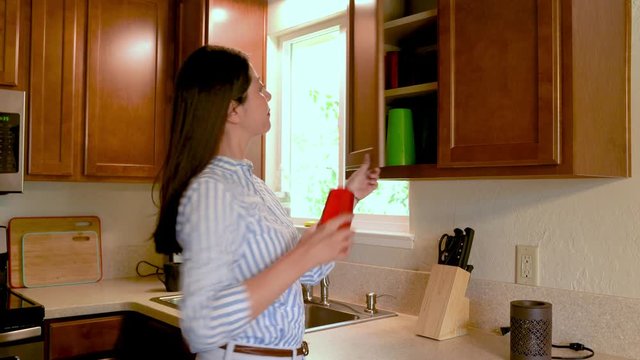 thirsty asian woman drinking water smiling healthy lifestyle. young lady walk in kitchen open cupboard taking out glass cup and using fridge for clear water. female with refrigerator dispenser.