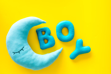 Naklejka premium Baby shower concept. Word Boy and moon toy on yellow background top view