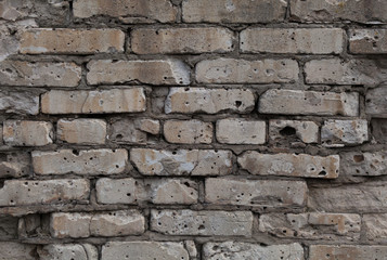 Closeup of gray old brick wal with a textured surface as a background.