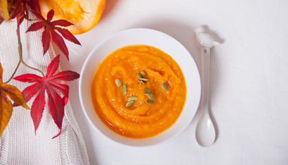 Pumpkin soup in a white bowl on thewhite table. Autumn concept. Harvest.