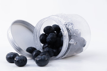 Close-up of a can of blueberries scattered on a table insulated on a white background