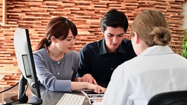 産婦人科医の説明を受ける夫婦