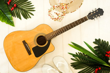 Camping or adventure trip scenery concept. Backpack, guitar, boots, belt, thermos and camera on wooden background captured from above (flat lay). Layout with free text (copy) space.