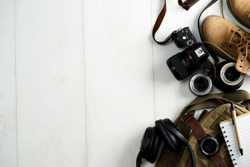 Camping or adventure trip scenery concept. Backpack, boots, belt, thermos and camera on wooden...