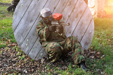 Active paintball game. Paintball player in protective uniform and mask close-up.