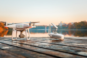 Drone copter with digital camera, blur river on autumn background