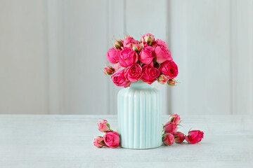 Bouquet of pink roses in blue ceramic vase. Postcard motif.