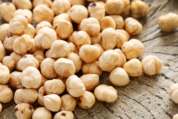 Hazelnuts on rough wooden background.