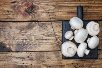 Fresh mushrooms champignons on a wooden background. Close-up Space for text.