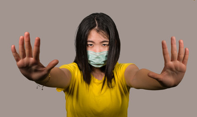 young beautiful pacifist Asian woman in face mask angry and outraged protesting showing clean hands as symbol of peace standing for freedom and human rights isolated