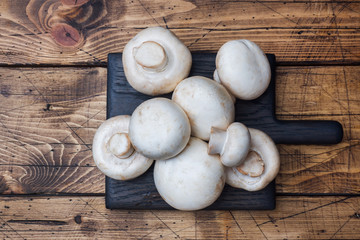 Fresh mushrooms champignons on a wooden background. Close-up Space for text.