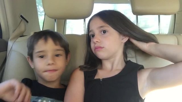   Aprende a pronunciar brother and sister playing imitate adults in the backseat of a car on a family trip