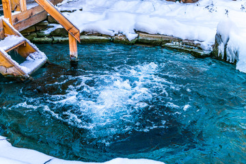 Natural jacuzzi outdoors at winter. Natural swimming pool surrounded by snow in the winter