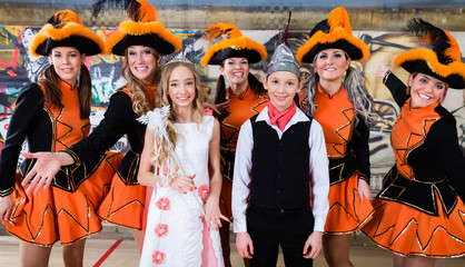 Kids as royal couple of German fasching with uniformed cheerleader dance group
