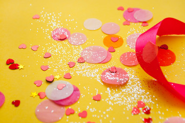 Colorful confetti, sparkles on bright yellow background. Festove background.