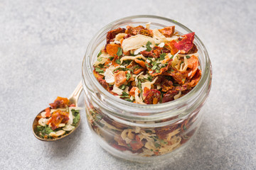 Dried spices, sun-dried tomatoes, dried carrots, Basil and herbes de Provence in a glass jar Copy space.