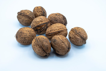 Freshly harvested organic wallnuts, white background.