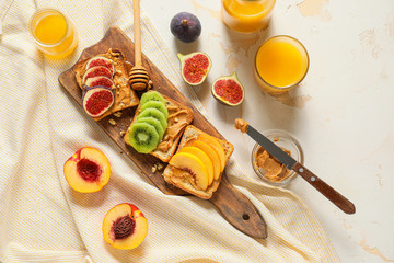 Wooden board with tasty sweet sandwiches on table