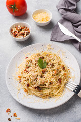 Spaghetti pasta Bolognese with vegetable sauce and cheese. Portion on a plate. Light concrete background.