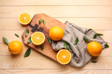 Board with fresh oranges on wooden table