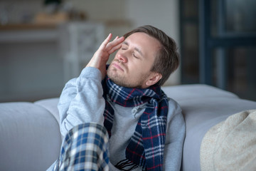 Dark-haired young man suffering from strong headache