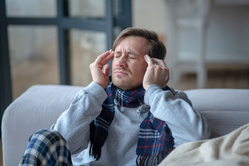 Man struggling with headache while having high fever