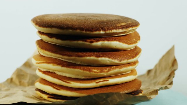 Another pancake is placed on a stack of pancakes