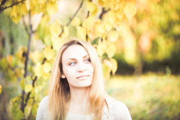 Blue eyed girl in autumn yellow leaves