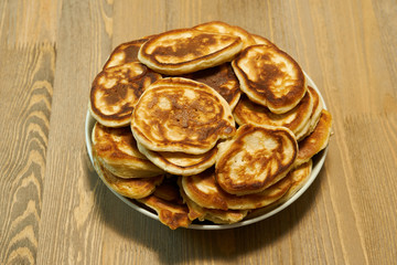 Stack of delicious homemade pancakes on plate, wooden table as background