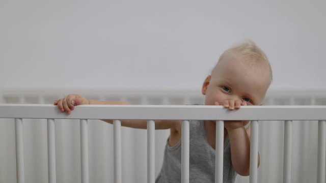 cute smiling baby boy playing in cot