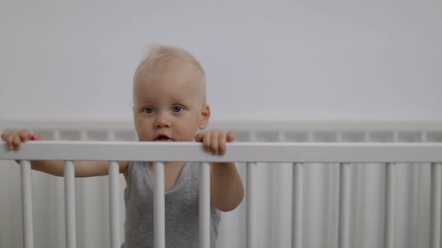 cute smiling baby boy playing in cot