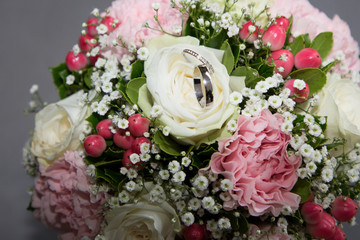 Obraz na płótnie Canvas Pair of wedding rings flowers bridal bouquet