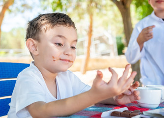 Littile arabic boy enjoying eating chocolate by him self