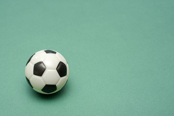 Fototapeta na wymiar Football ball on a green field flat lay background with copy space. Game plan template.