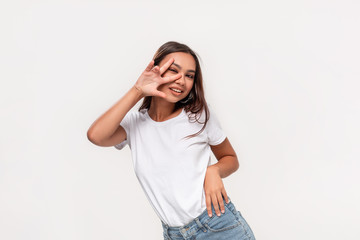 Beautiful african-american teenager in a white t-shirt and blue jeans dancing isolated over white background.