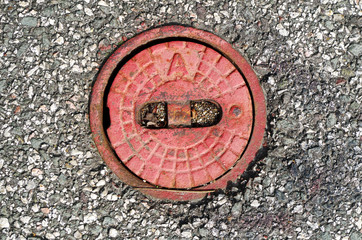 red metal cap in asphalt
