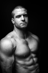 Fototapeta premium sports man standing on a black background, doing sports.