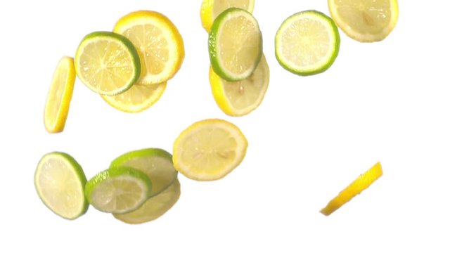 sliced lemon and lime flying in slow motion on white background