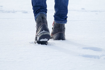 Walking in the snow. Closeup of winter shoes / boots. Man hiking.