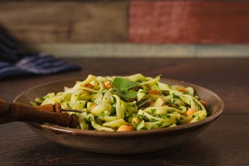 Linguine pasta with  chickpeas and green pesto in a rustic decor