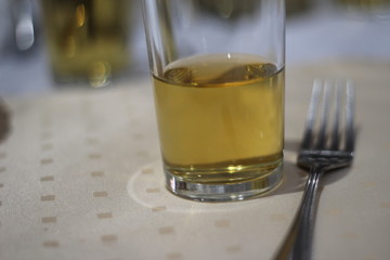 a glass of juice next to a fork