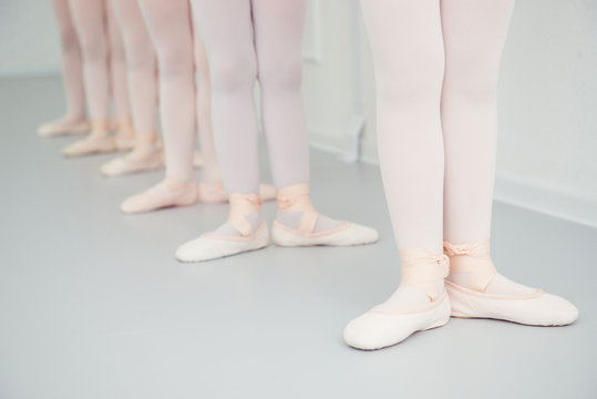 girls practice at ballet class, feet in ballet shoes closeup