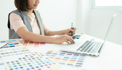 Graphic designer at work. Color swatch samples. Artist drawing something on graphic tablet at the office. Graphic designer creativity editor ideas designer concept 