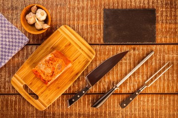 Fototapeta na wymiar Cutting raw pork chops. Marinated meat. Preparing for barbecue. Home preparation of pork. Pork chop on a kitchen board.