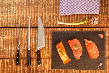 Cutting raw pork chops. Marinated meat. Preparing for barbecue. Home preparation of pork. Pork chop on a kitchen board.