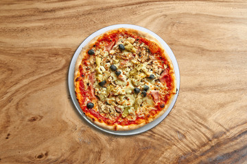 Delicious Four Seasons pizza on splendid wooden background