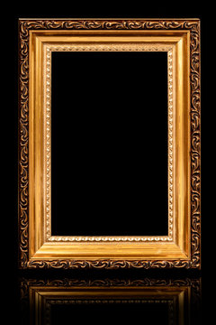 One beautiful old antique empty wooden gold frame on black background.