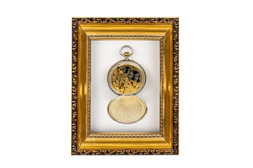 Old antique mechanical golden steel pocket watch with open lid inside a wooden gold frame isolated on white background.