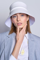 Gorgeous lady in cotton skirt and jacket slung over shoulders and white hat